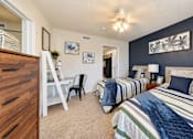 Thumbnail 6 of 22 - Two twin beds, a compact desk and a dresser in a furnished bedroom at Canterbury Apartments in Myrtle Beach, SC.