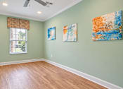 Thumbnail 18 of 22 - Yoga room with wood-look flooring, pale green walls and a window at Canterbury Apartments in Myrtle Beach, SC.