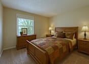 Thumbnail 4 of 18 - A bedroom with a bed, nightstands, and a window.