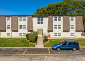 Thumbnail 16 of 18 - an apartment building with a blue van parked in front of it