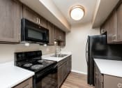 Thumbnail 1 of 18 - redesigned kitchen with black appliances and white countertops in an apartment