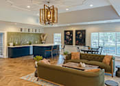 Thumbnail 21 of 24 - A living room with a green couch and a chandelier.