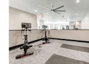 Thumbnail 16 of 19 - A room with exercise bikes and yoga mats.