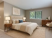 Thumbnail 6 of 23 - A bedroom with a large bed, a nightstand, a chair, and a painting on the wall.