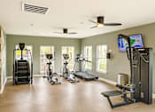 Thumbnail 11 of 24 - A spacious home gym with a variety of exercise equipment.