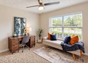 Thumbnail 5 of 18 - Furnished room with a desk, bookcase, and upholstered daybed beside a large window at Icon Cartersville.