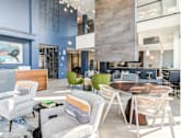 Thumbnail 6 of 19 - A modern living room with a blue accent wall and a variety of seating options.