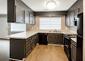 Thumbnail 3 of 17 - A kitchen with black cabinets and a white countertop.