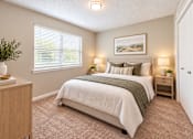 Thumbnail 9 of 15 - Bright apartment bedroom with carpet, large window, closet doors, and neutral finishes at Madison Park in Birmingham, AL.