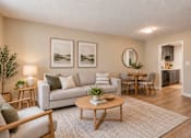 Thumbnail 7 of 15 - Bright apartment living area with wood-style flooring and adjoining dining space at Madison Park Apartments & Townhomes in Birmingham.