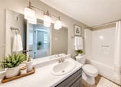 Thumbnail 6 of 15 - Apartment bathroom with vanity, tub and shower combination, and wood-style flooring at Madison Park Apartments & Townhomes in Birmingham, AL.