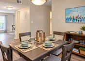 Thumbnail 3 of 15 - Dining area with wood-style flooring and space for a four-person table at Madison Park Apartments & Townhomes in Birmingham, AL.