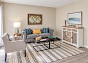 Thumbnail 1 of 15 - Apartment living room with wood-style flooring and spacious seating area at Madison Park Apartments & Townhomes in Birmingham, AL.