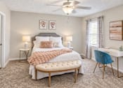 Thumbnail 4 of 15 - Spacious apartment bedroom with carpet, ceiling fan, window, and workspace at Madison Park Apartments & Townhomes in Birmingham, AL.