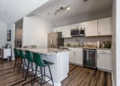 Thumbnail 18 of 23 - kitchen area of remodeled clubhouse. Granite countertops, seating at island, stainless steal appliances.