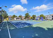 Thumbnail 30 of 30 - A tennis court with a blue surface and white lines.