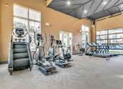 Thumbnail 8 of 25 - A gym with treadmills, elliptical machines, and a stair climber.