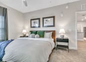 Thumbnail 22 of 25 - A bedroom with a large bed and two framed pictures on the wall.