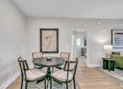 Thumbnail 17 of 25 - A dining room with a table and chairs.