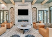 Thumbnail 11 of 25 - A living room with a fireplace and a television above it.