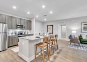 Thumbnail 1 of 25 - A modern kitchen with a dining table and chairs.
