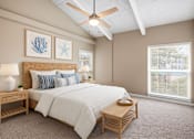 Thumbnail 6 of 16 - A bedroom with a bed, nightstand, and a ceiling fan.