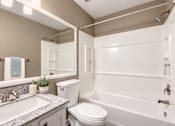 Thumbnail 18 of 24 - Bathroom with a rectangular sink, patterned countertop and bathtub at Waterchase Apartments in Largo, FL.