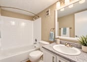 Thumbnail 17 of 24 - Bathroom with an oval sink and tiled bathtub surround at Waterchase Apartments in Largo, FL.