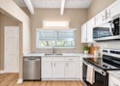 Thumbnail 3 of 24 - Kitchen with white cabinetry and a window at Waterchase Apartments in Largo, FL.