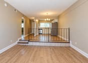 Thumbnail 14 of 24 - Unfurnished living room with steps and a railing separating the raised dining area at Waterchase Apartments in Largo, FL.