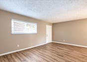 Thumbnail 9 of 24 - Unfurnished living room with a wide window and wood-look flooring at Waterchase Apartments in Largo, FL.