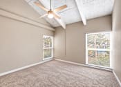 Thumbnail 7 of 24 - Unfurnished bedroom with exposed ceiling beams, a ceiling fan and carpet at Waterchase Apartments in Largo, FL.