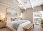 Thumbnail 6 of 24 - Virtually staged bedroom with a vaulted ceiling, exposed beams, large windows and coastal decor at Waterchase Apartments in Largo, FL.