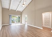 Thumbnail 5 of 24 - Unfurnished living room with a vaulted ceiling, exposed beams and balcony doors at Waterchase Apartments in Largo, FL.