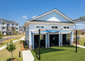 Thumbnail 13 of 28 - outdoor green yoga lawn just outside the fitness center with garage doors rolling up.  The lawn is partially covered and shaded.