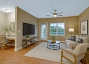 Thumbnail 35 of 37 - A living room with a television, a couch, and a coffee table.