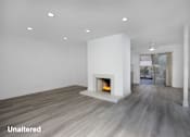 Thumbnail 9 of 63 - A modern living room with a fireplace and wood flooring.