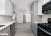 Thumbnail 11 of 63 - A kitchen with white cabinets and a black stove top oven.