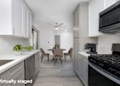 Thumbnail 12 of 63 - A kitchen with white cabinets and a black stove top oven.