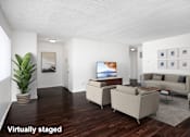 Thumbnail 9 of 18 - A living room with a couch, chair, and television.