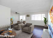Thumbnail 7 of 18 - A living room with a couch, chairs, and a coffee table.