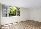 Thumbnail 7 of 45 - A room with a window and wooden flooring.