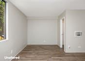 Thumbnail 6 of 45 - A room with wooden flooring and white walls.