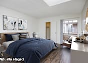 Thumbnail 10 of 19 - A bedroom with a bed, nightstand, and a painting on the wall.