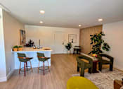 Thumbnail 4 of 57 - A living room with a bar area and a green chair.