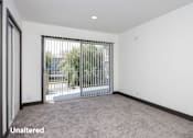 Thumbnail 4 of 52 - A room with a sliding door leading outside.