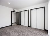 Thumbnail 50 of 52 - a living room with white walls and doors and a carpet