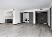 Thumbnail 44 of 52 - an empty living room with a washer and dryer in it and grey doors