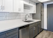 Thumbnail 51 of 52 - an empty kitchen with white countertops and a stainless steel sink