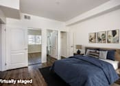 Thumbnail 8 of 34 - A bedroom with a bed, dresser, and mirrors.